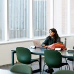 Student studying in the curtin library, smiling out the window