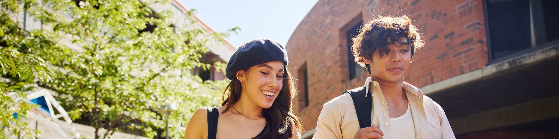 Two students smiling walking on campus together.