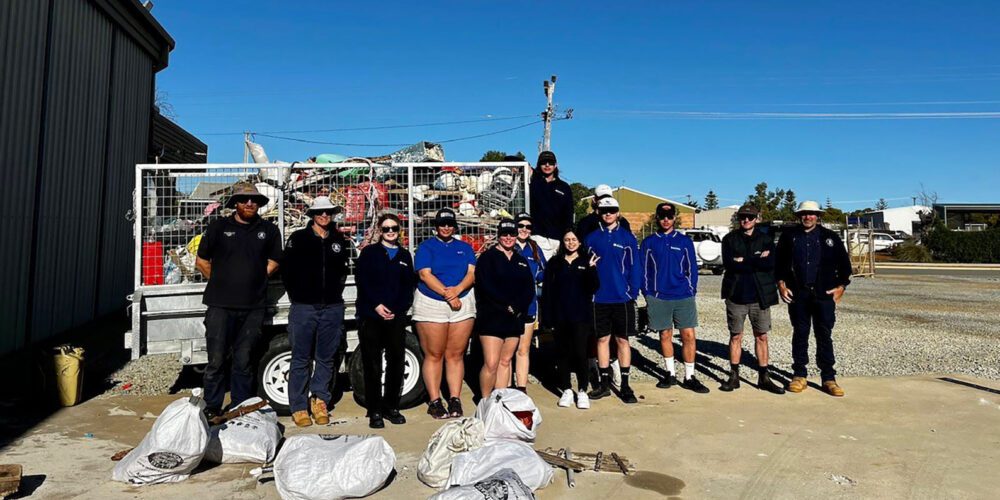 Team of students and staff standing with the collected marine debris.
