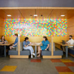 Group of students sitting a some cafe tables