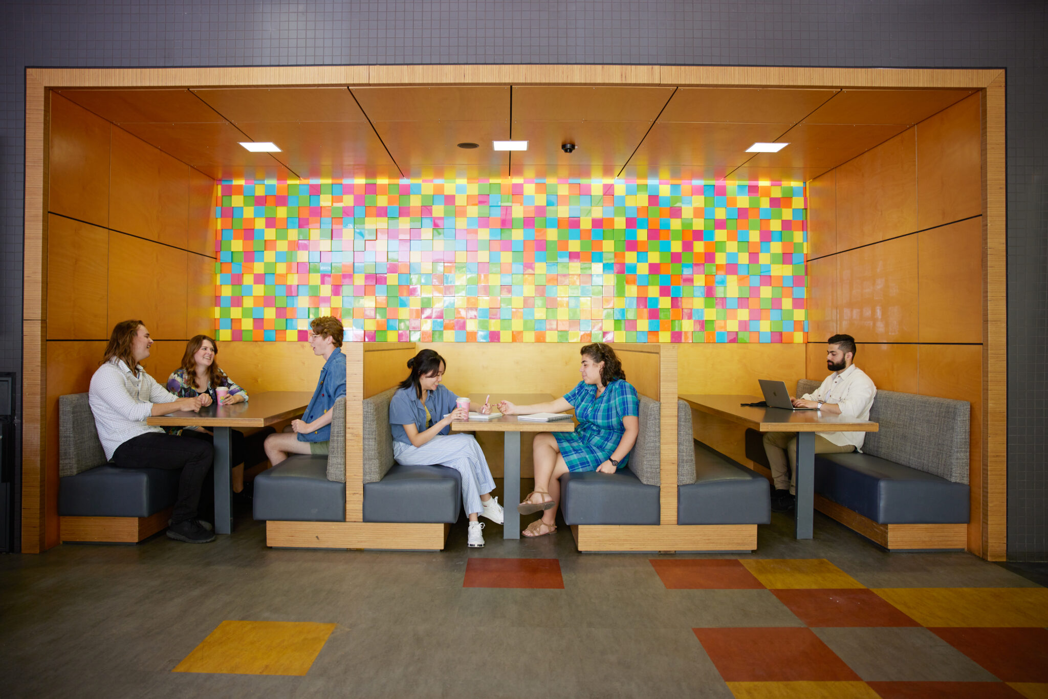 Group of students sitting a some cafe tables