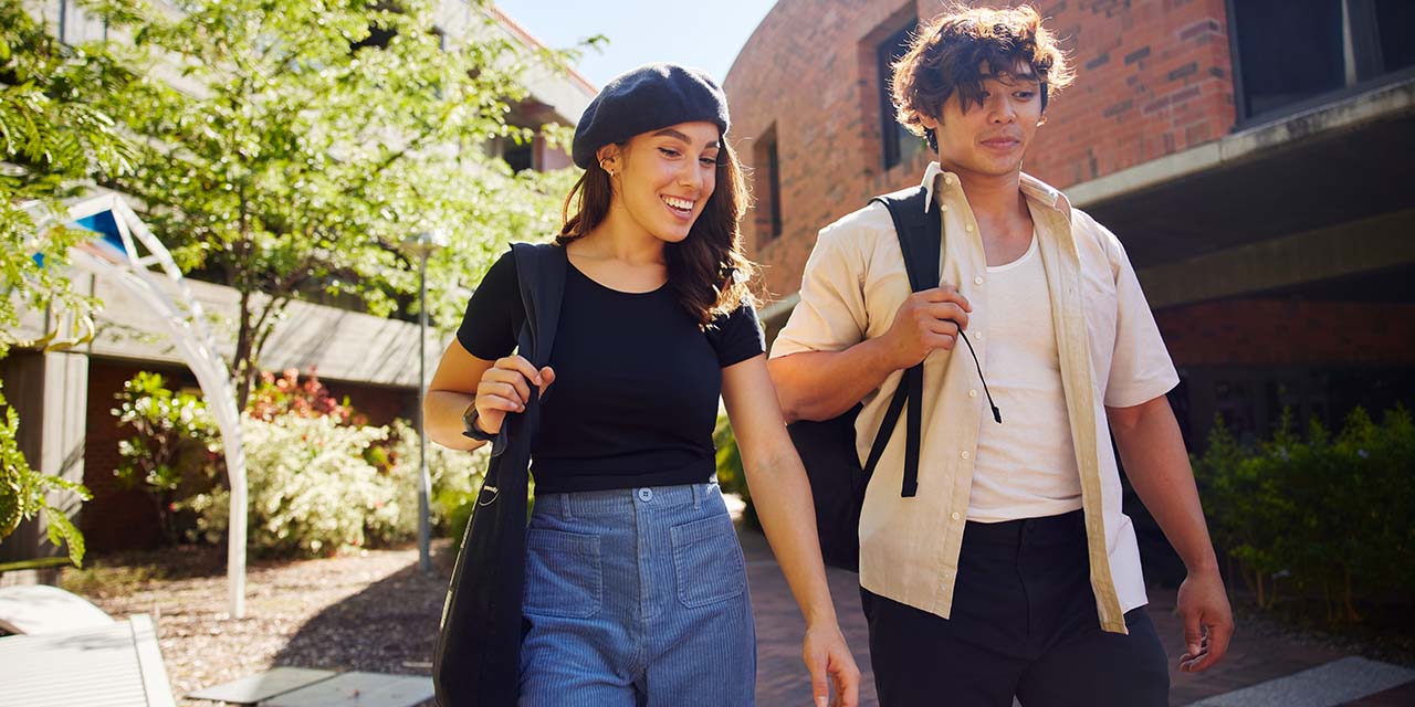 Male and female student walking through Bentley Campus