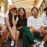 A diverse group of male and female students sitting outside a Curtin building at Bentley Campus.