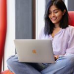 Student using their laptop and smiling