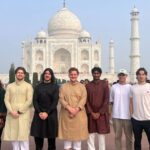 A group of business and law students standing in front of the Taj Mahal in India.