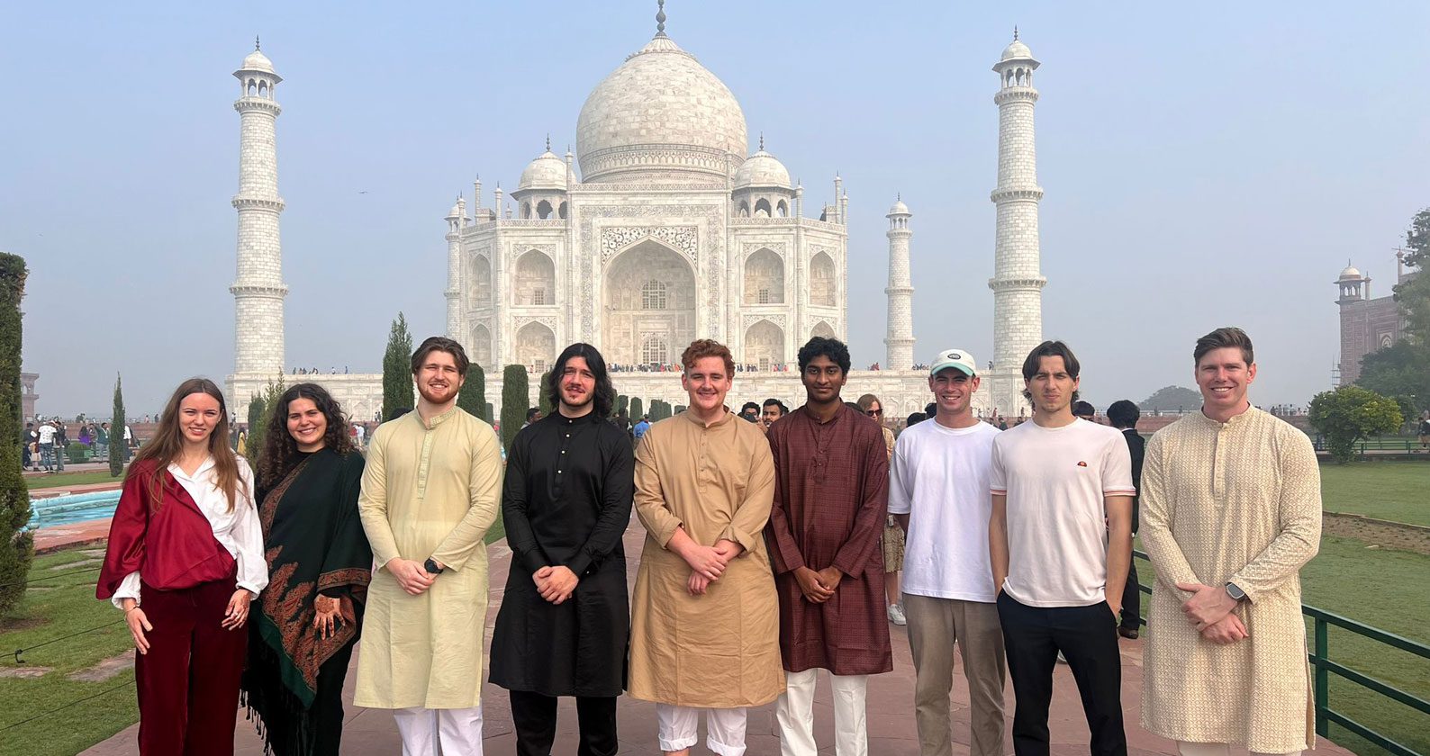 A group of business and law students standing in front of the Taj Mahal in India.