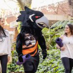 Two students walking on campus with Carl the Carnaby.