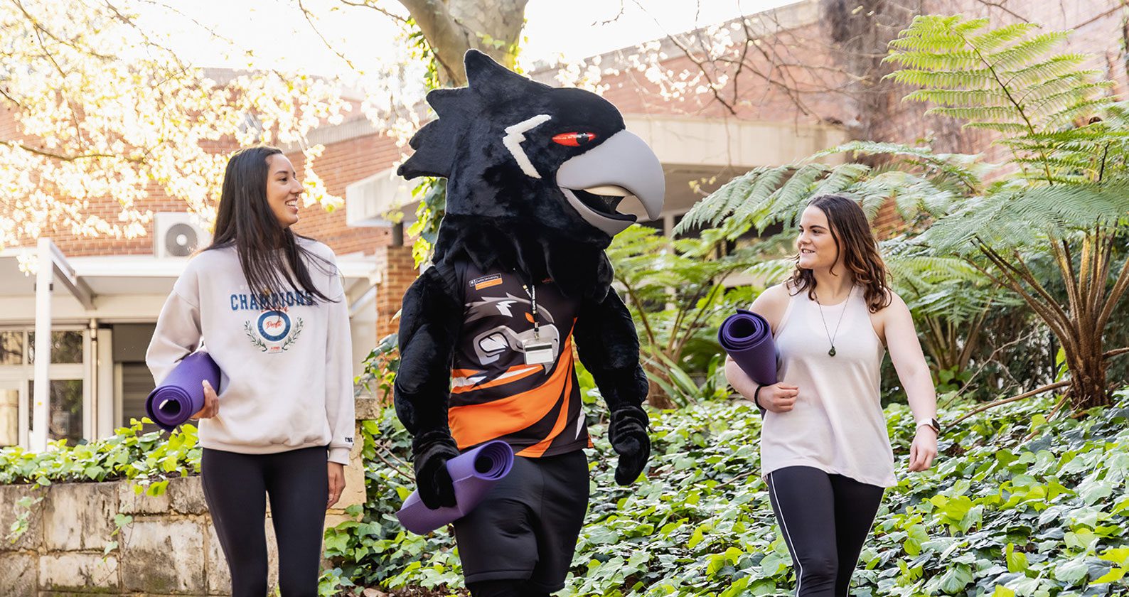 Two students walking on campus with Carl the Carnaby.