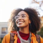 A student smiles into the distance. The sun illuminates her hair.