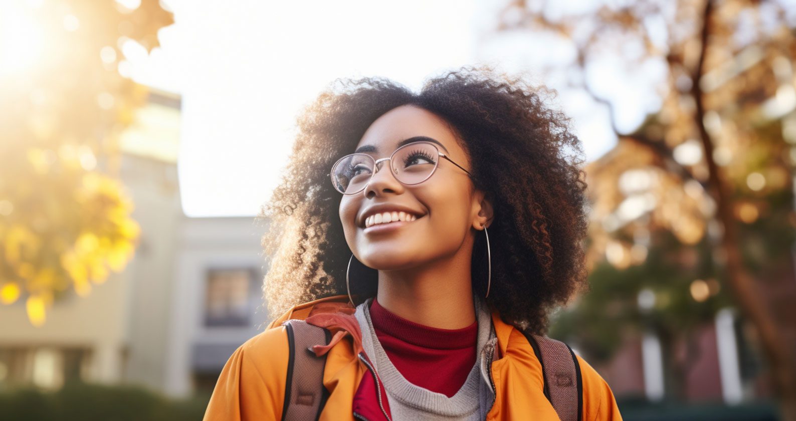 A student smiles into the distance. The sun illuminates her hair.