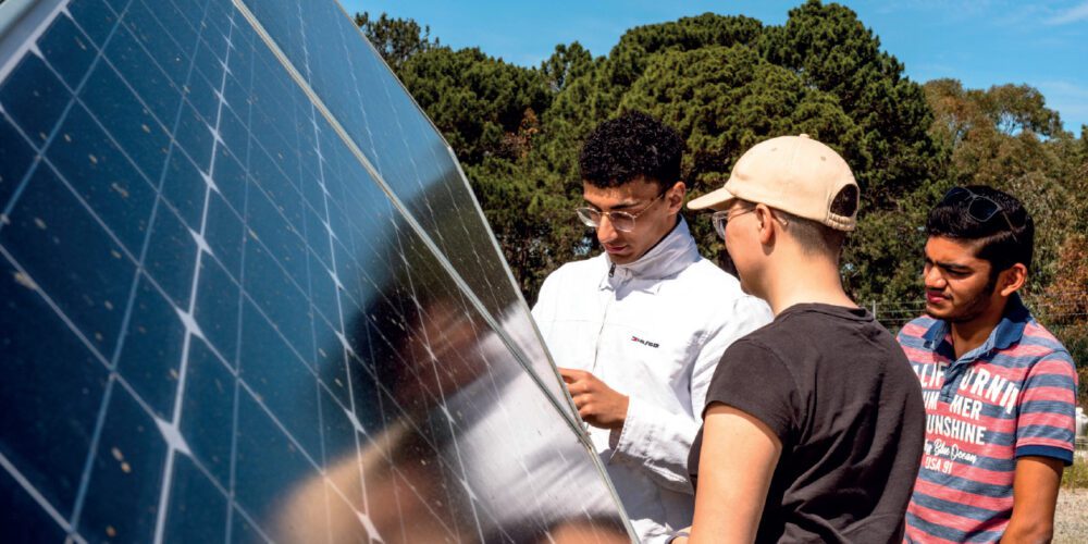 Three students examining a solar panel in Curtin’s Green Electric Park (GEEP) facility.