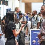 A male student speaking with an employer at a Careers Fair event