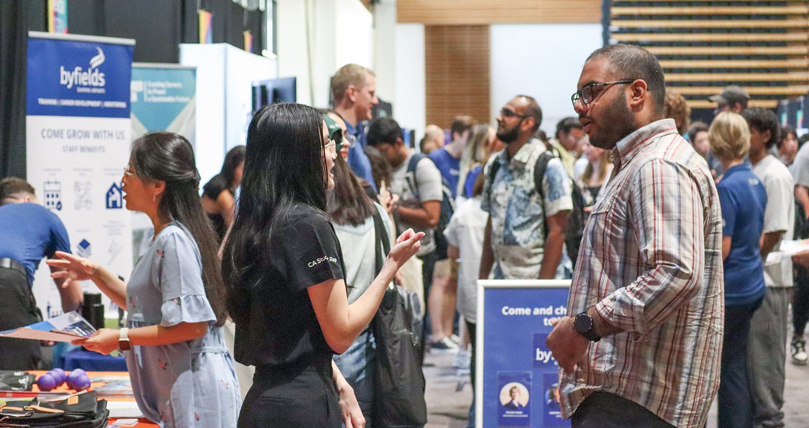 A male student speaking with an employer at a Careers Fair event