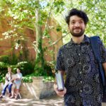 student walking on campus with book