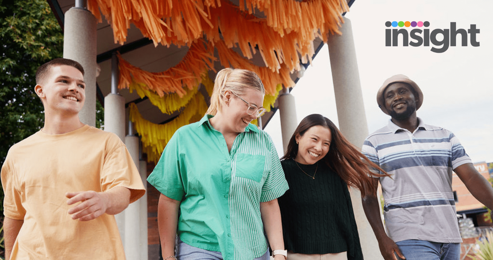 Four students standing together smiling