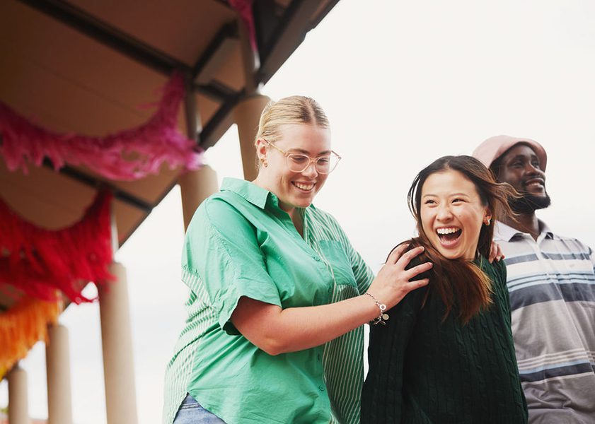 three students walking and laughing together