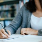 Student writing on a notepad.