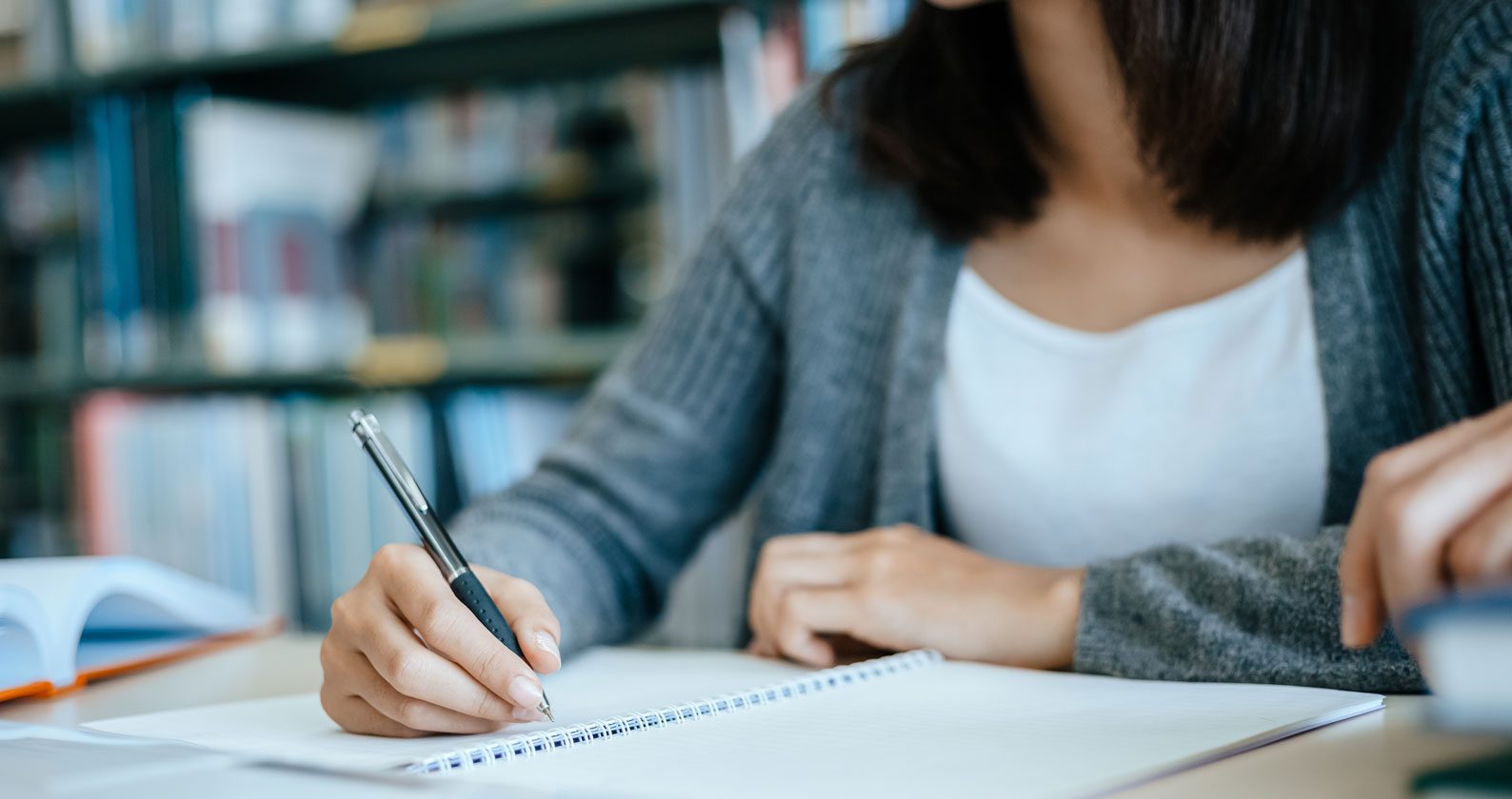 Student writing on a notepad.