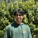 Rohan smiles at the camera whilst outdoors