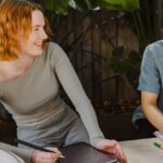 Two students laughing while studying outdoors.