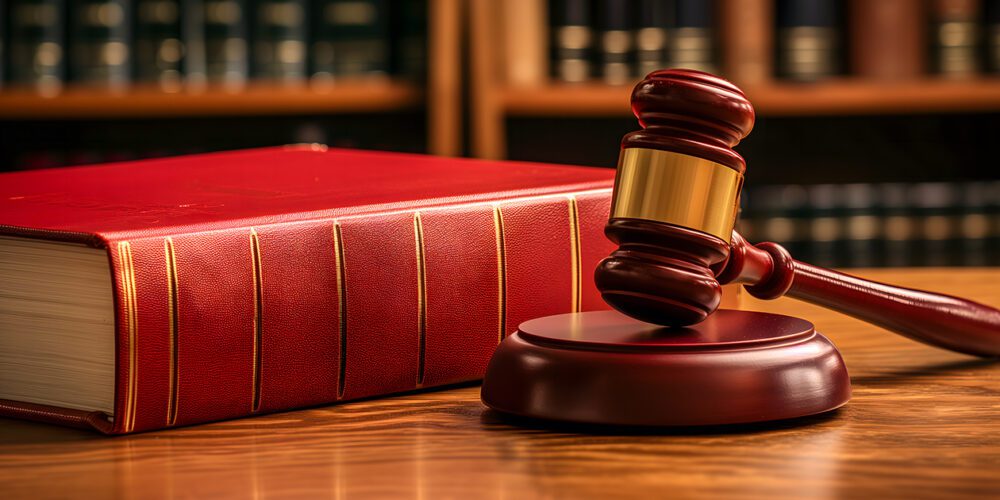 A gavel and a law book on a table in a law library.