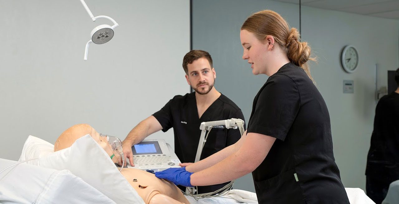 Two student nurses at Curtin working on a model patient