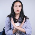 A young woman crossing her arms across her body.