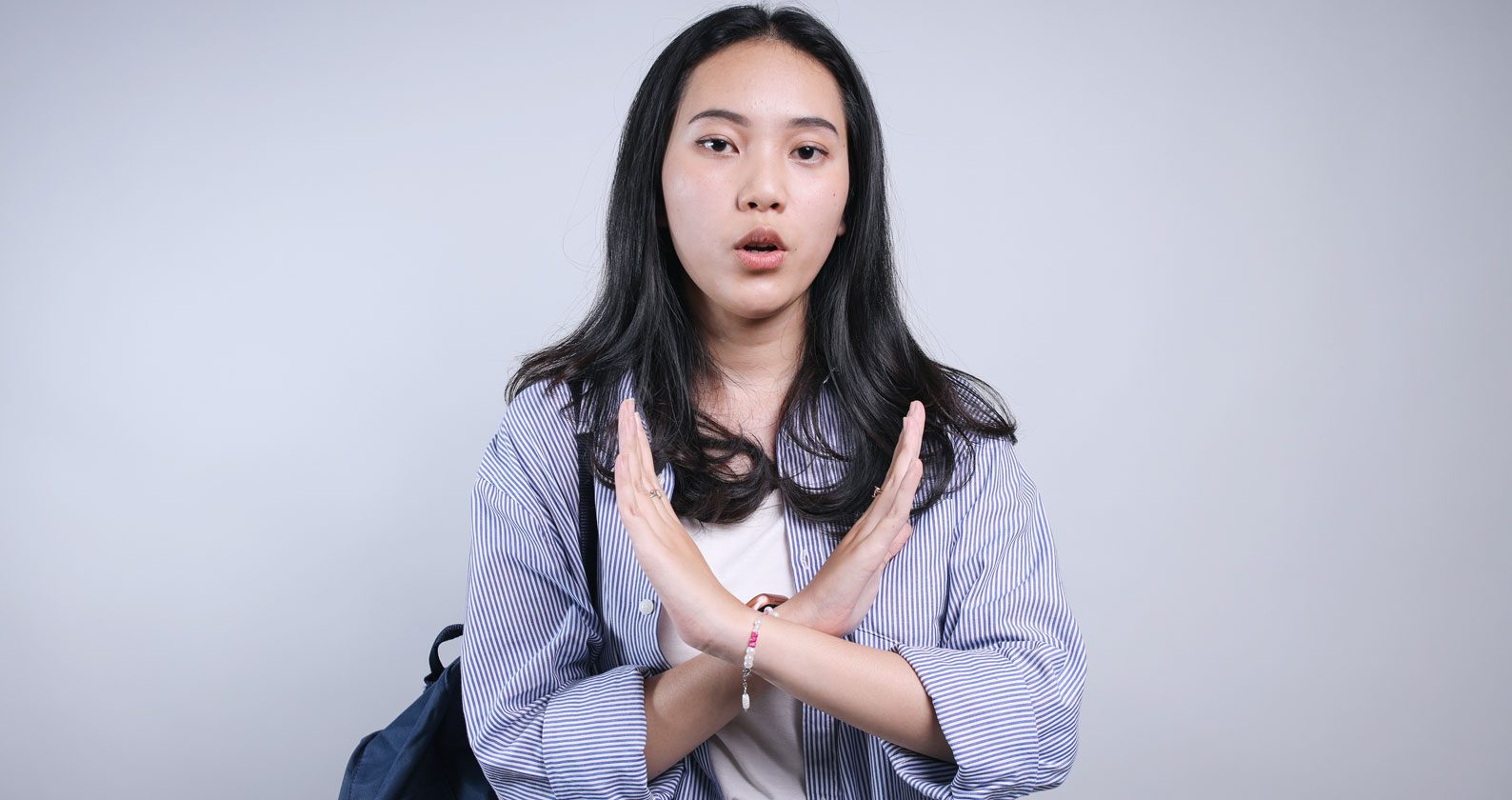 A young woman crossing her arms across her body.