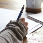 A hand using a pen to write.
