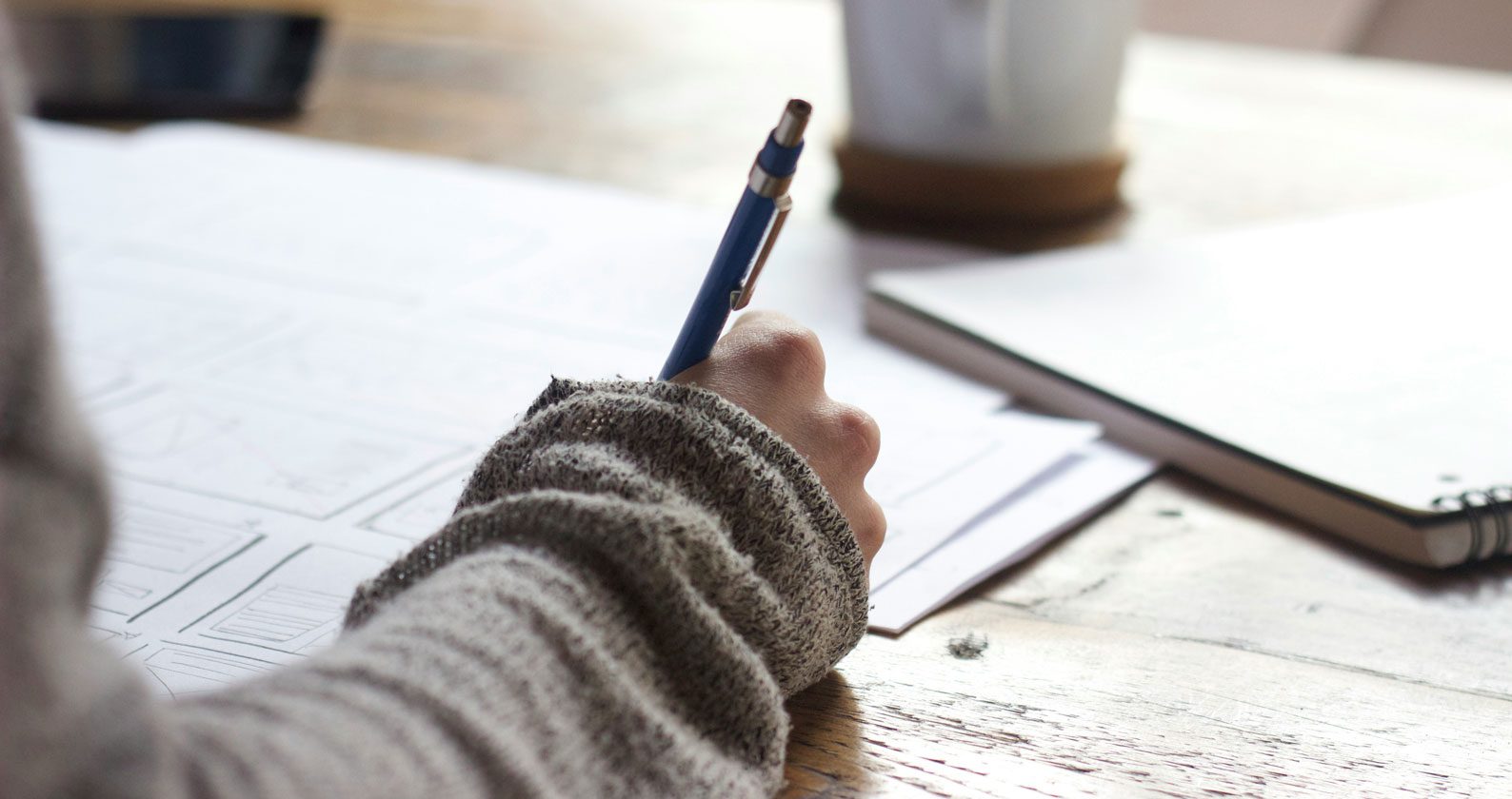 A hand using a pen to write.