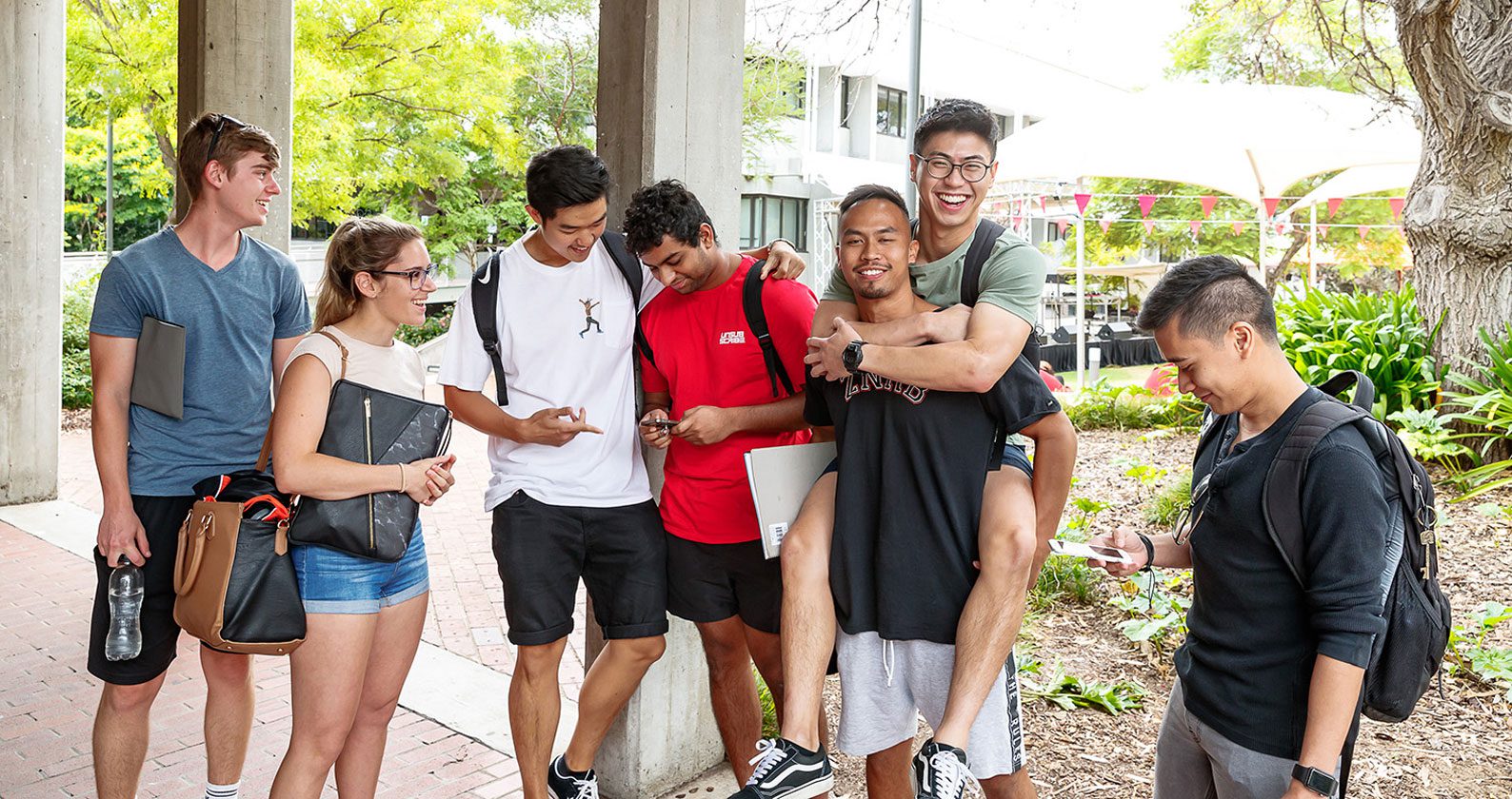 A group of students laughing and socialising.