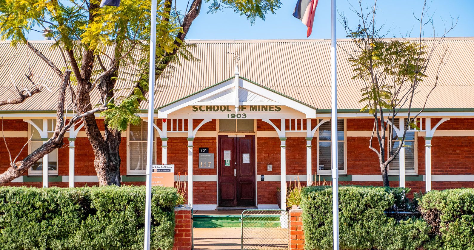 A brick building with trees out the front.