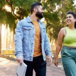 Two Curtin University students smiling at each other while walking to the right
