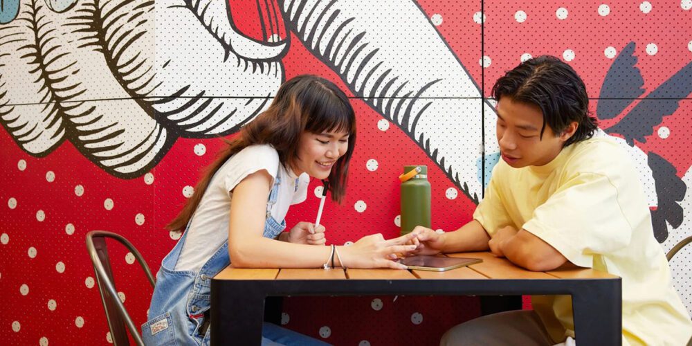 Two Curtin University students working on an iPad on the Curtin University Bentley Campus