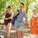 Three Curtin University students walking on campus and smiling.