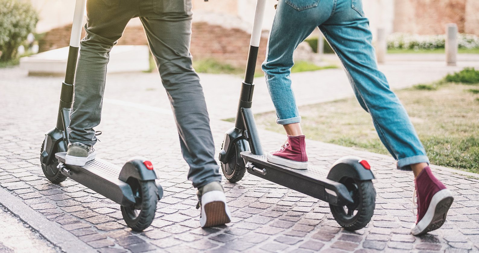Two people riding e-scooters