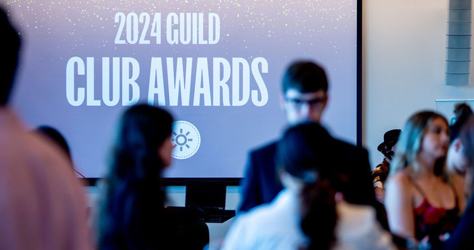 A crowd gathers in front of the 2024 Guild Club Awards signage