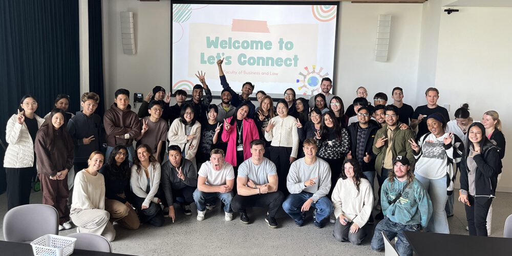 A group of Faculty and Business Law students (30+) smile for a group photo at Let's Chat.