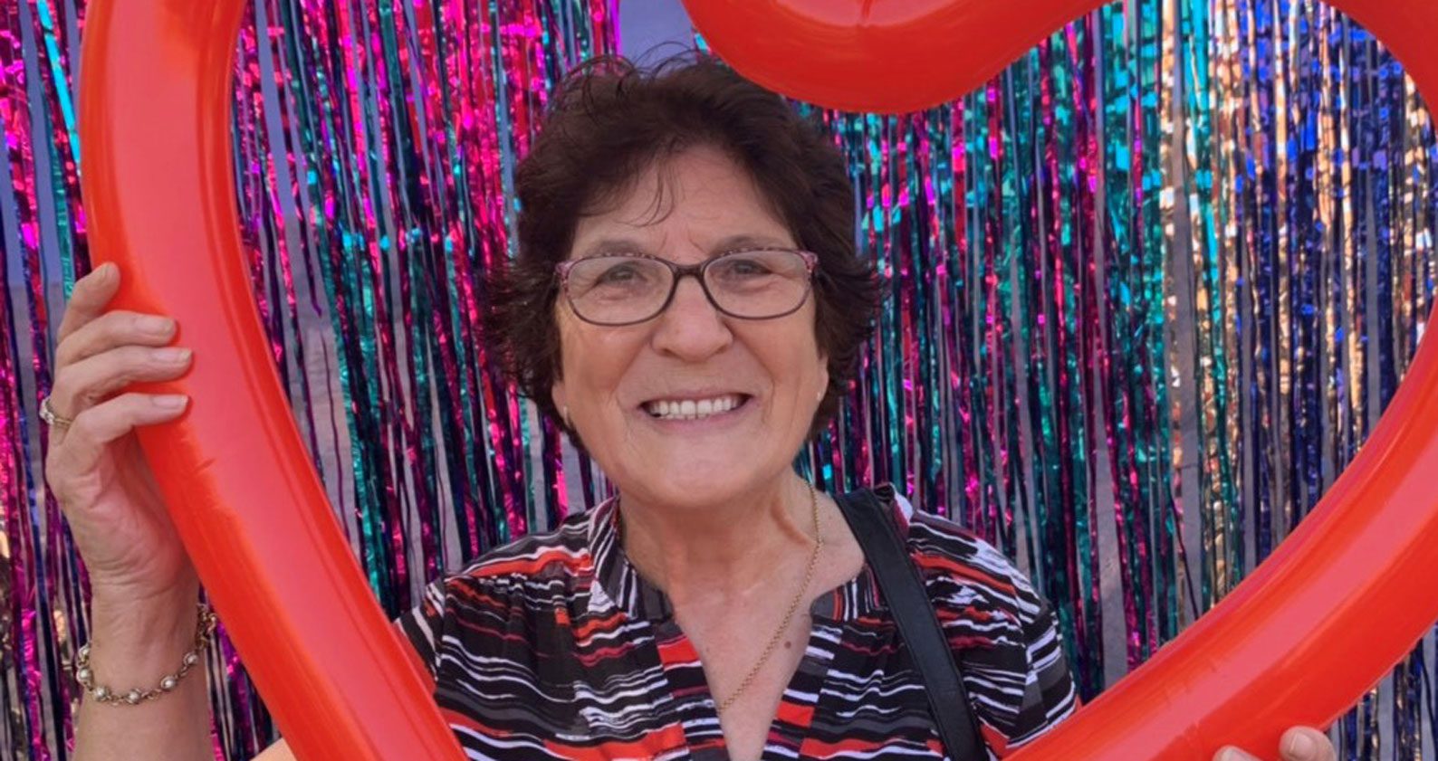 Rina smiles at the camera surrounded by a red heart.