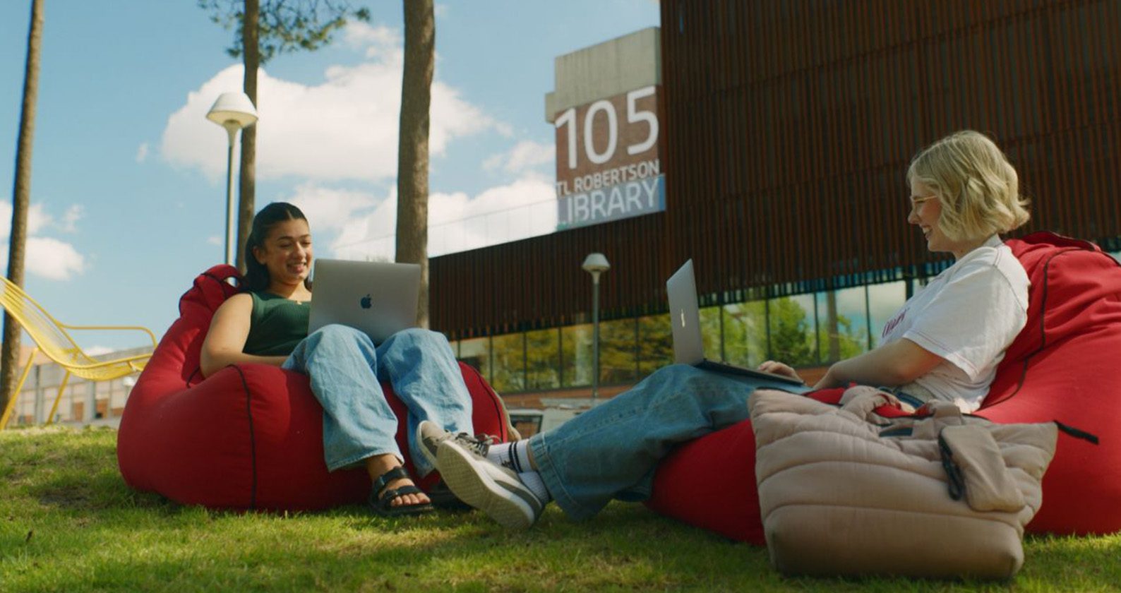 Two female students sitting on beanbags and working on laptops at the Curtin Bentley campus.