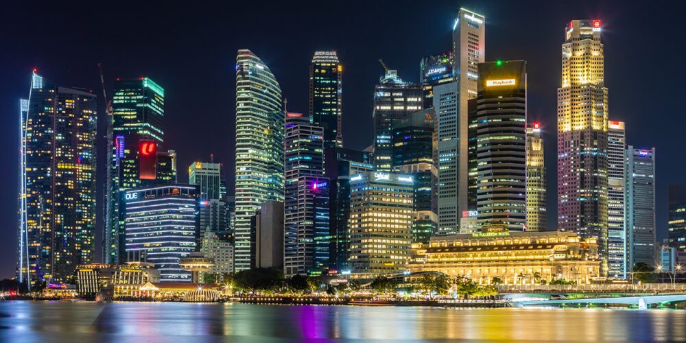 City skyline at night in Marina Bay, Singapore – a smart city. Fluorescent city lights glow bright.