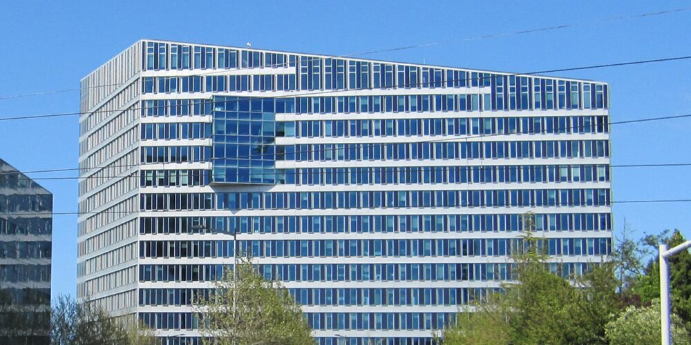 A big, almost-square smart building covered in windows. The image is of The Edge in Amsterdam, shot during the day.