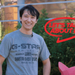 Mark stands in front of greenery
