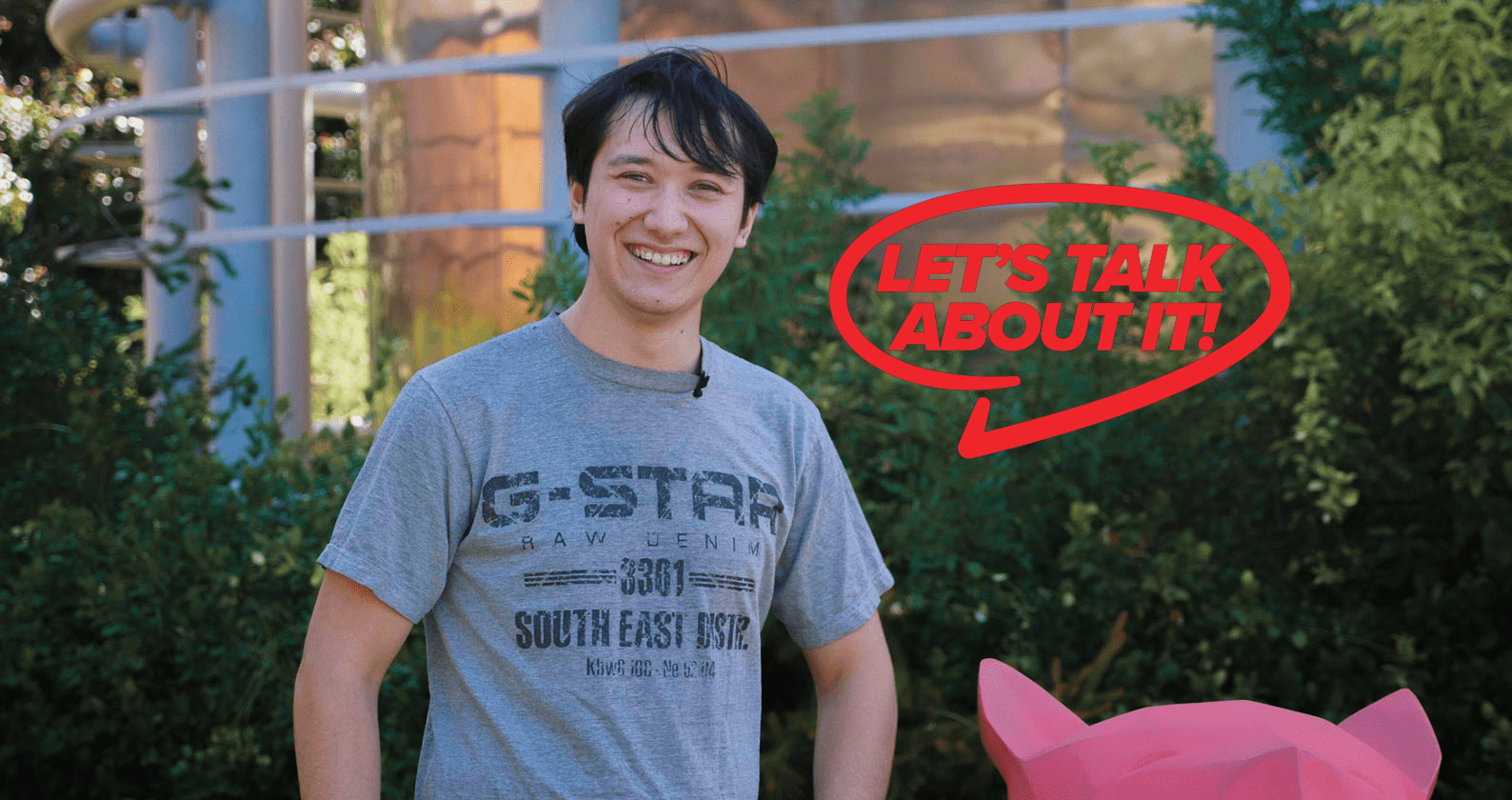 Mark stands in front of greenery