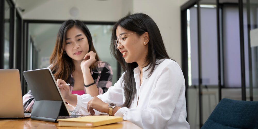 A female university student and staff member working on digital tablet. Visualises the capstone experience at Curtin University.