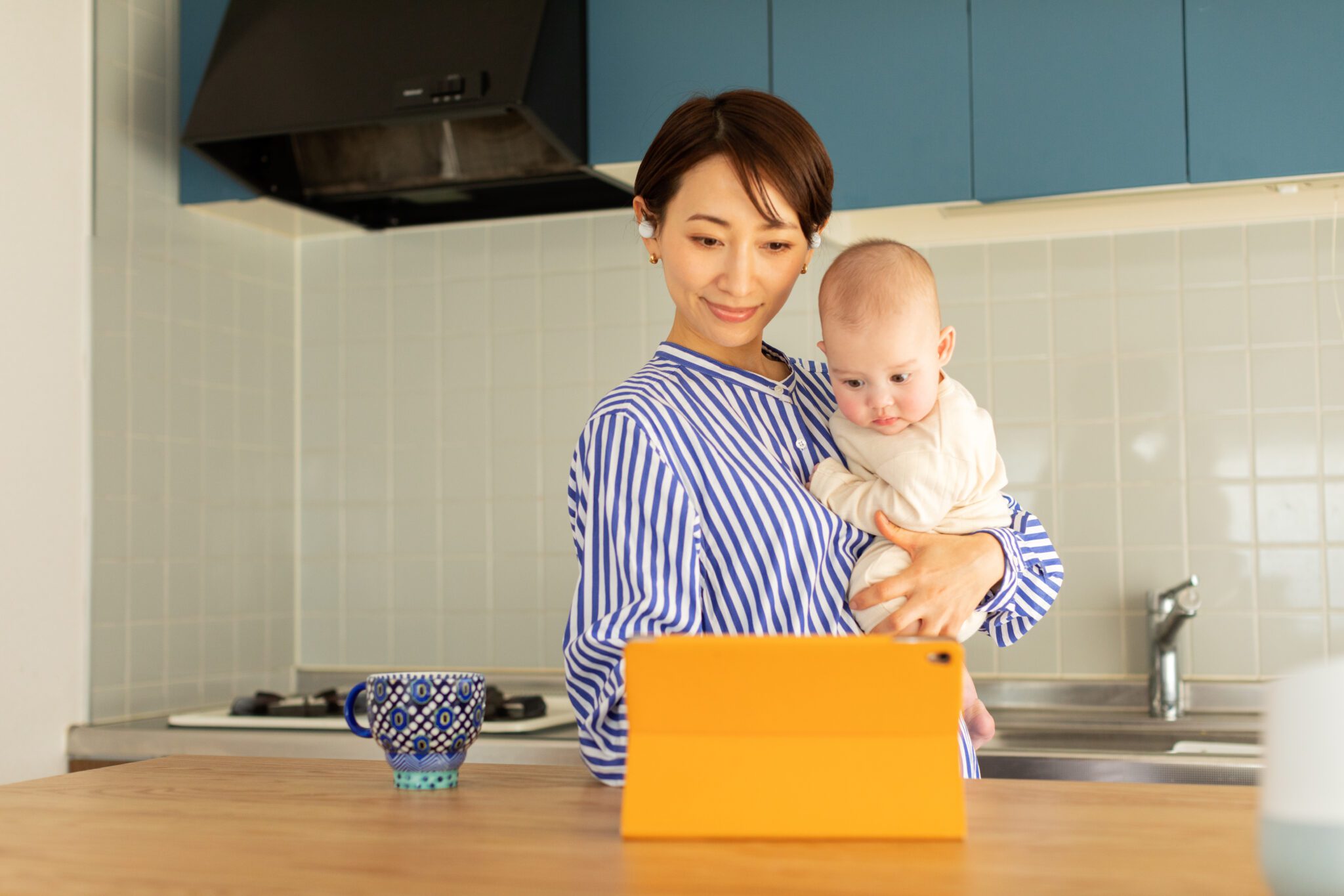 Mother holding infant using digital tablet