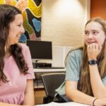 Two students looking at each other and smiling.