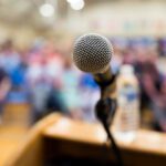 A microphone in front of a blurry audience.
