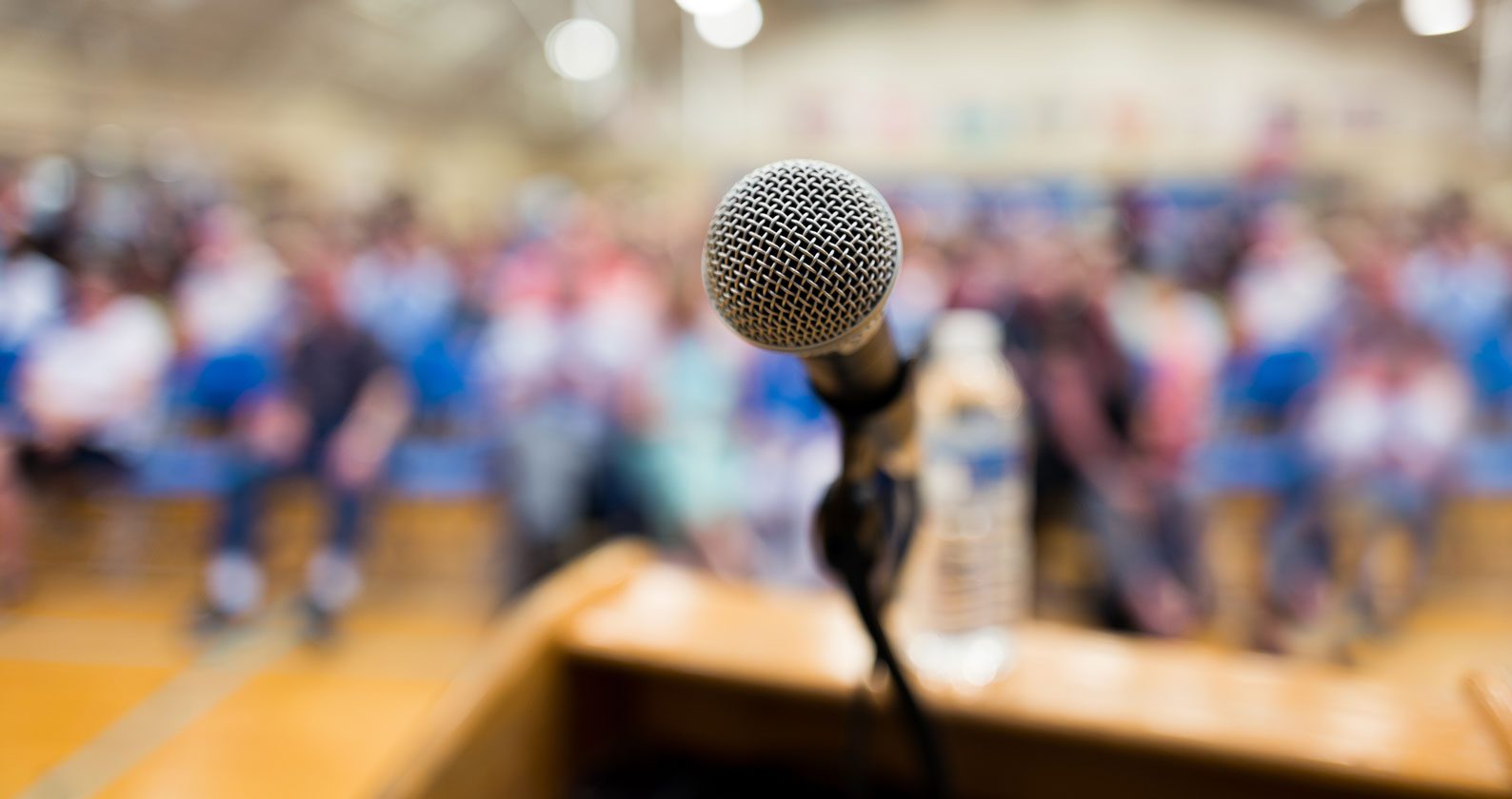A microphone in front of a blurry audience.