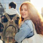Woman smiling at the camera while her companions face away.